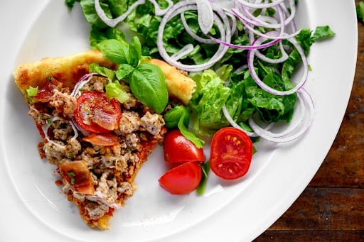 plate with pizza and salad greens 